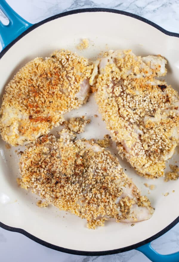 Chicken breasts coated in breadcrumb mixture sauteed in cast iron skillet.