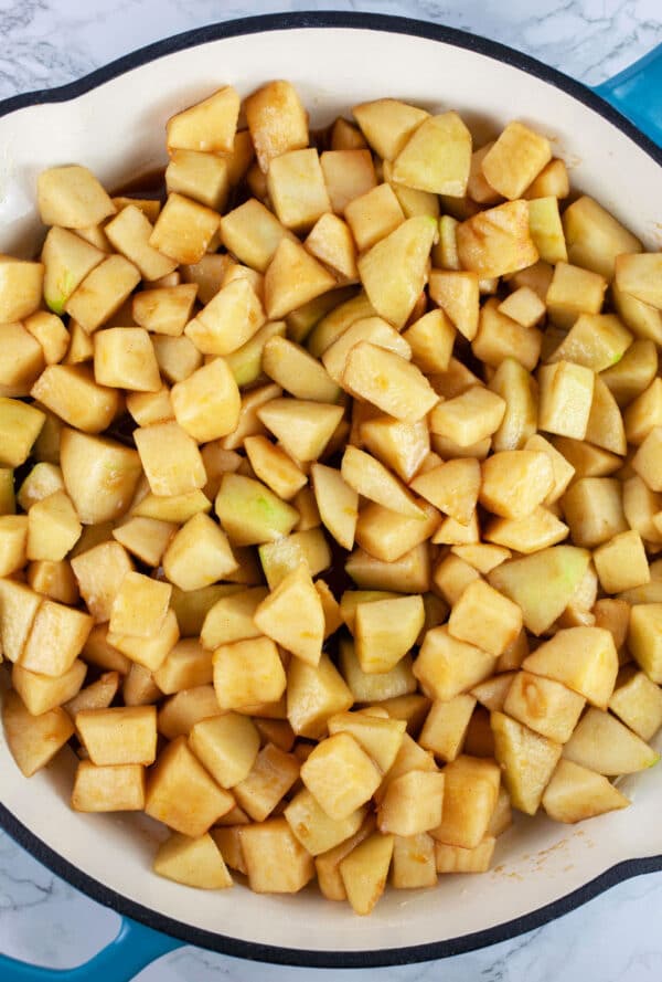 Uncooked diced apples in cast iron skillet.