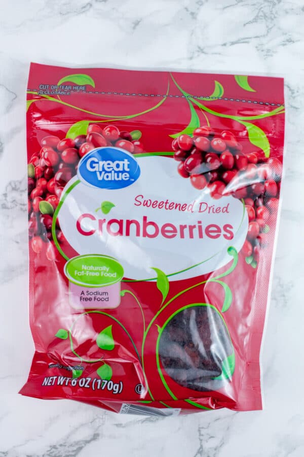Unopened bag of dried cranberries on white surface.