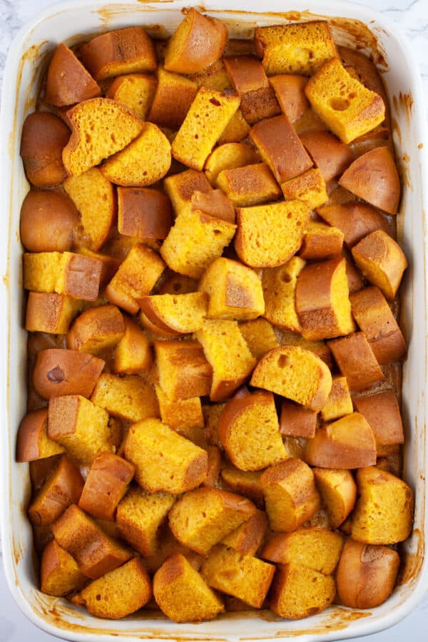 Baked pumpkin bread pudding in ceramic baking dish.