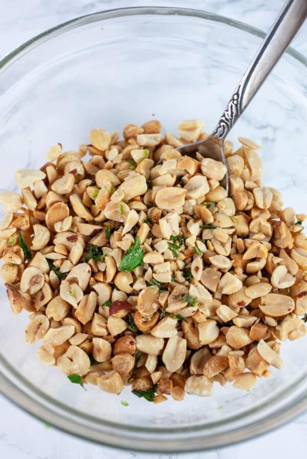 Peanut topping in glass bowl with spoon.
