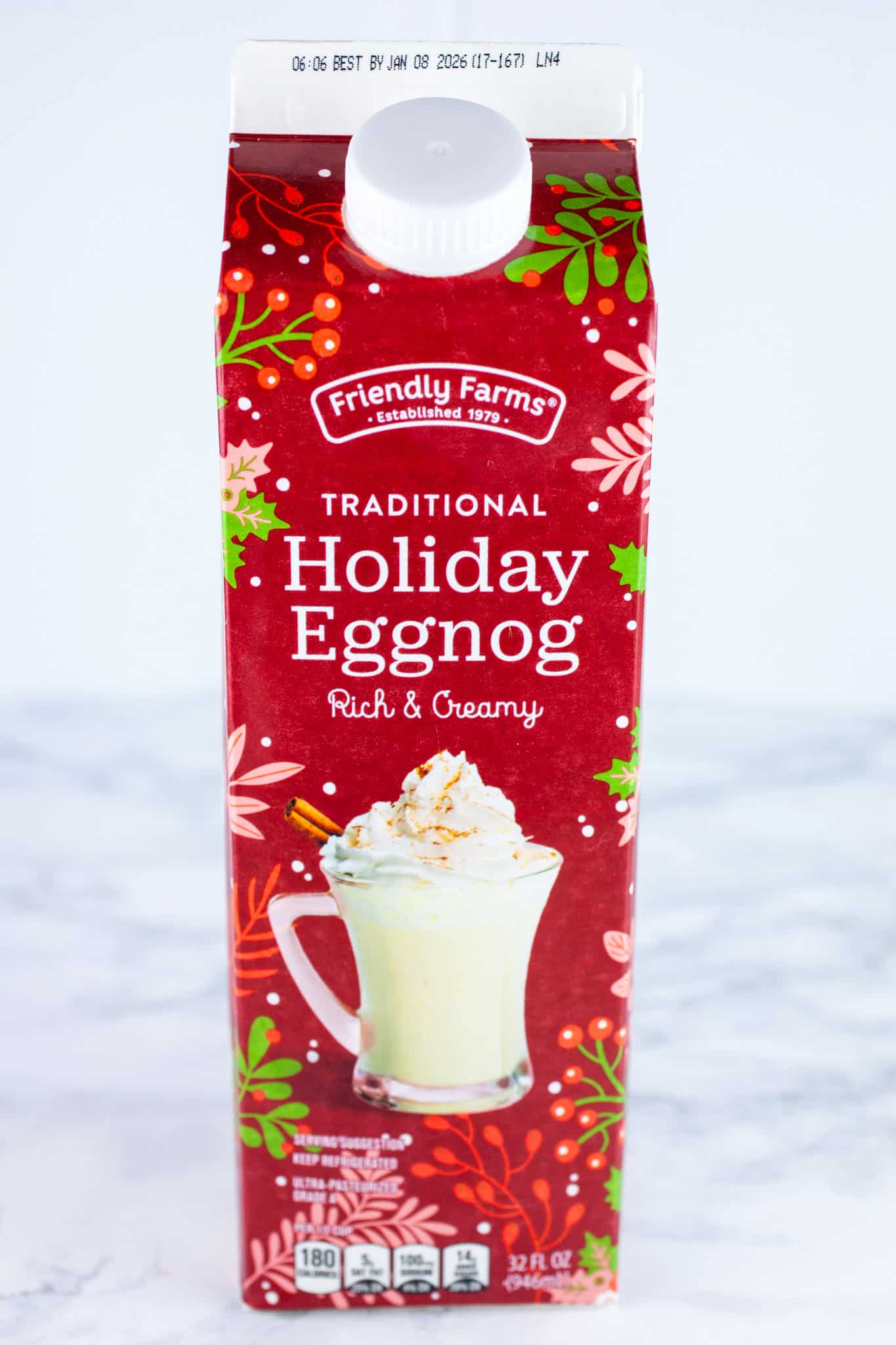 Cardboard carton of holiday eggnog on white surface.