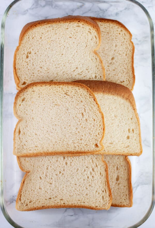 Sliced gluten free bread in glass cake pan.