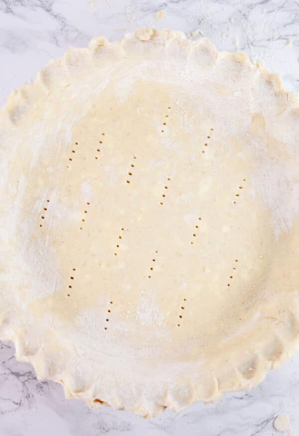 Unbaked gluten free pie crust pierced with a fork.