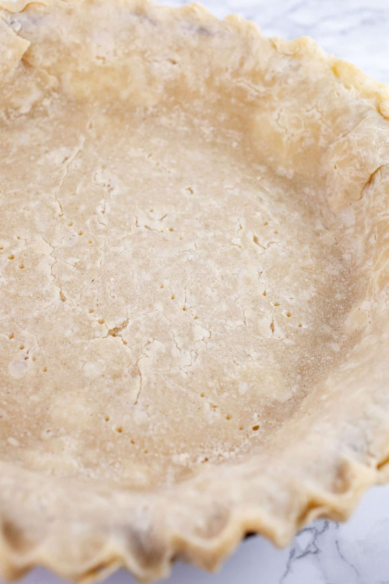 Par-baked gluten free pie crust in pie plate.