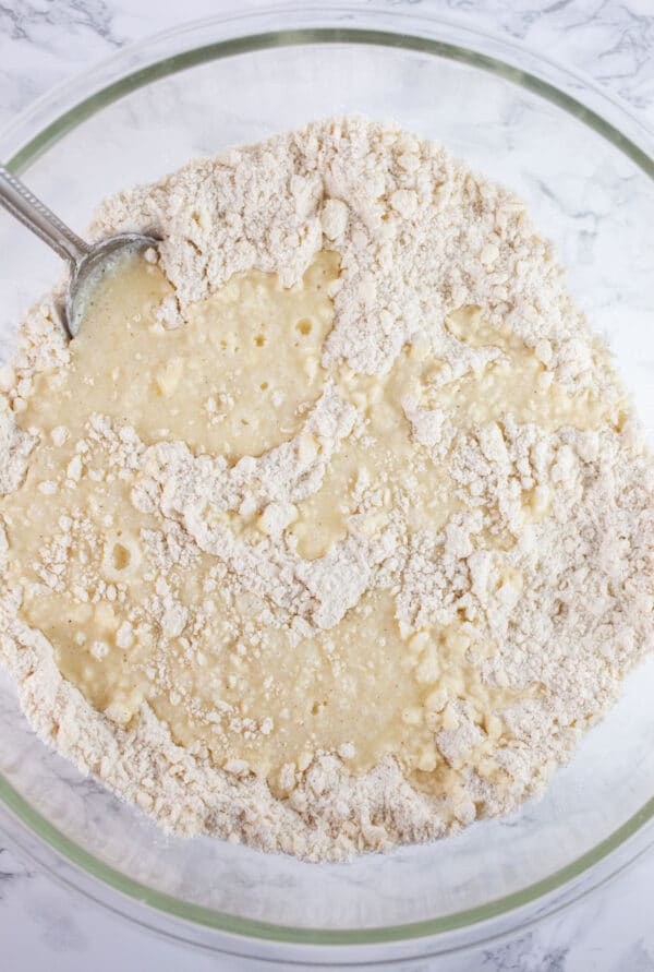 Egg and gluten free flour mixture in large glass bowl with spoon.