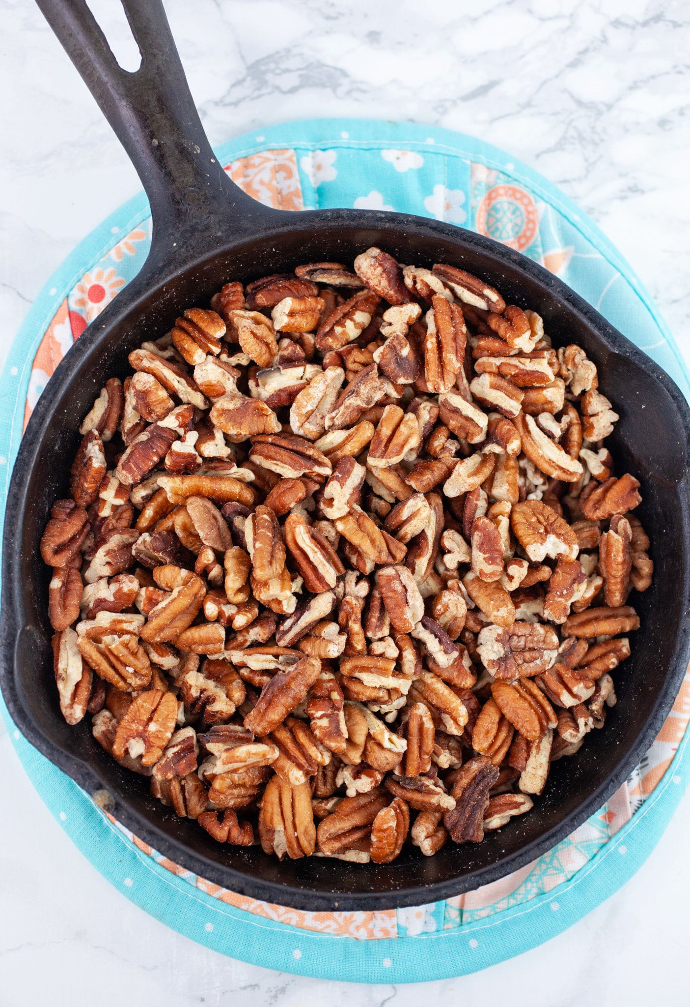 Toasted pecans in small cast iron skillet.