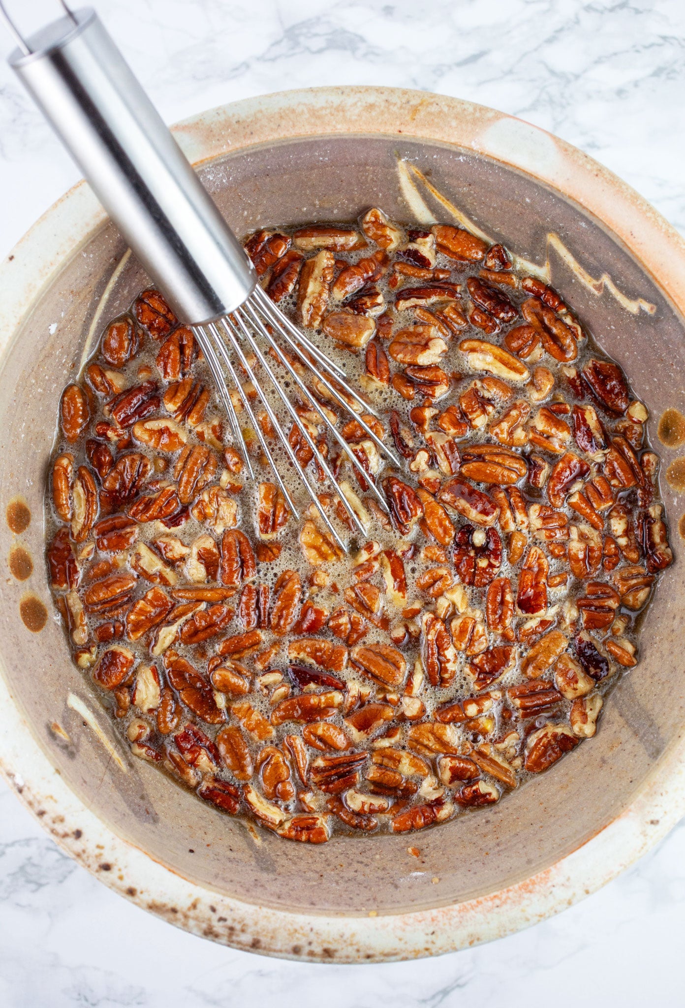 Maple pecan filling in ceramic bowl with whisk.