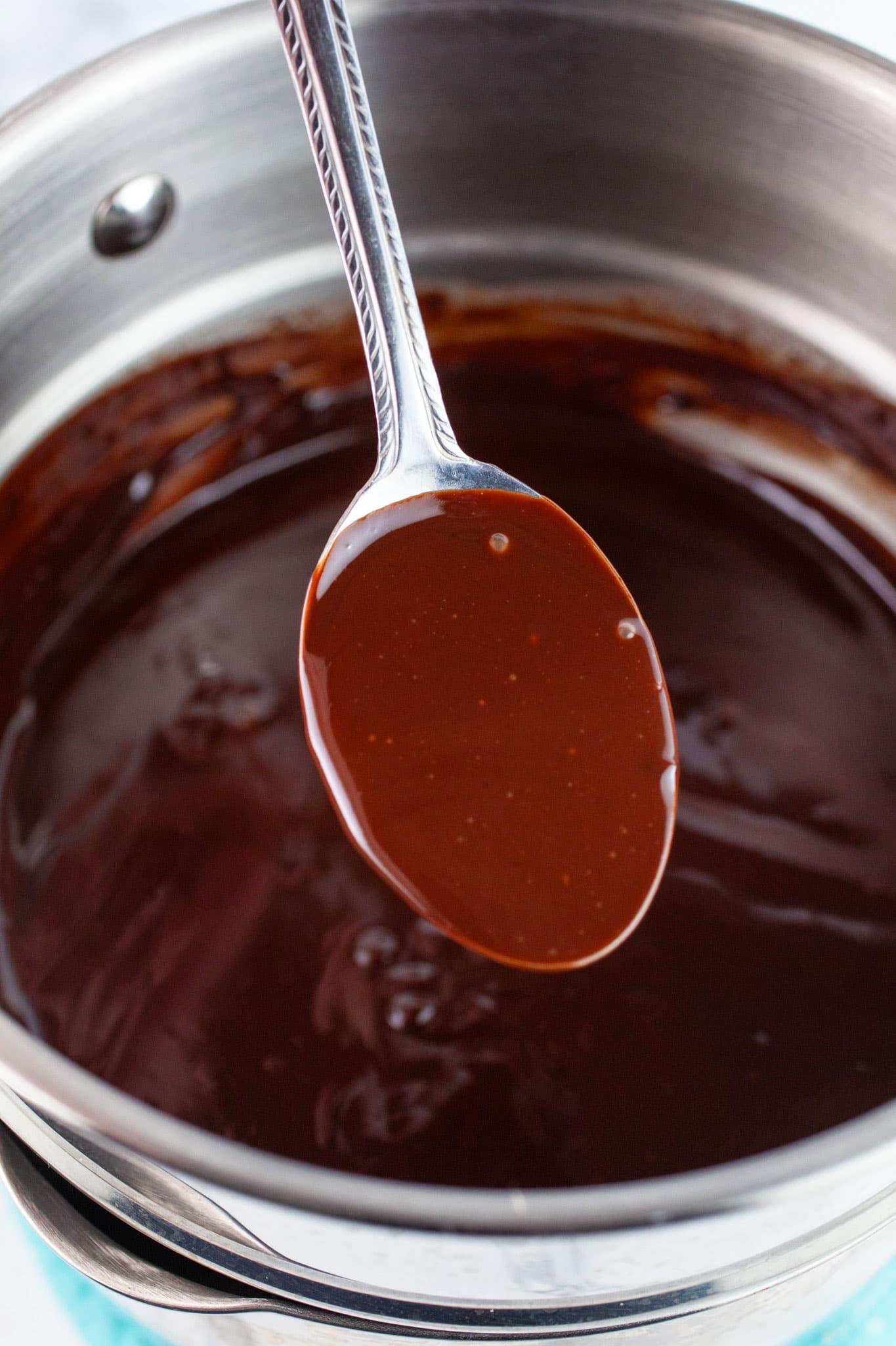 Spoonful of chocolate ganache lifted from double boiler.