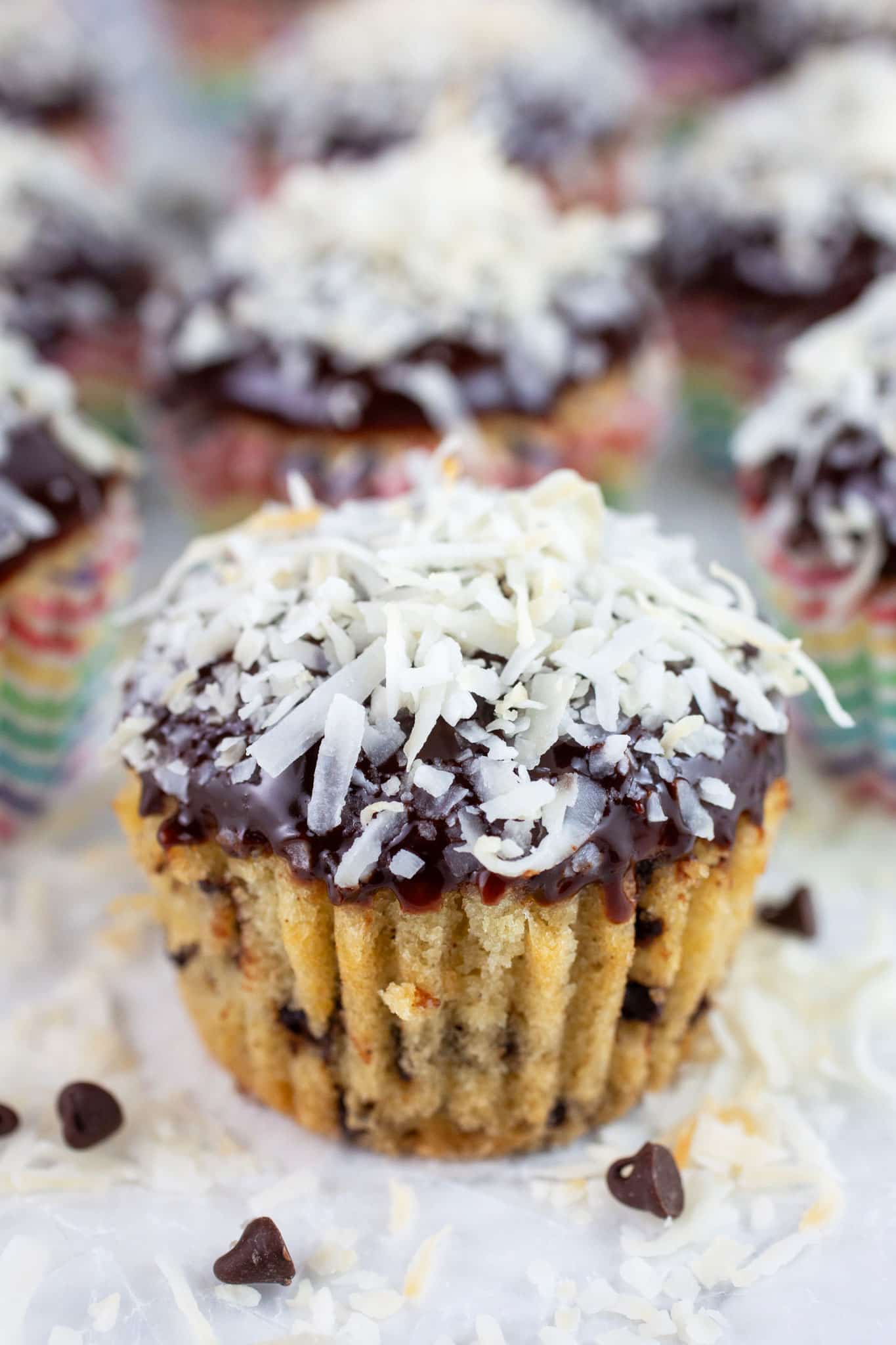 Coconut chocolate chip cupcakes on white surface.