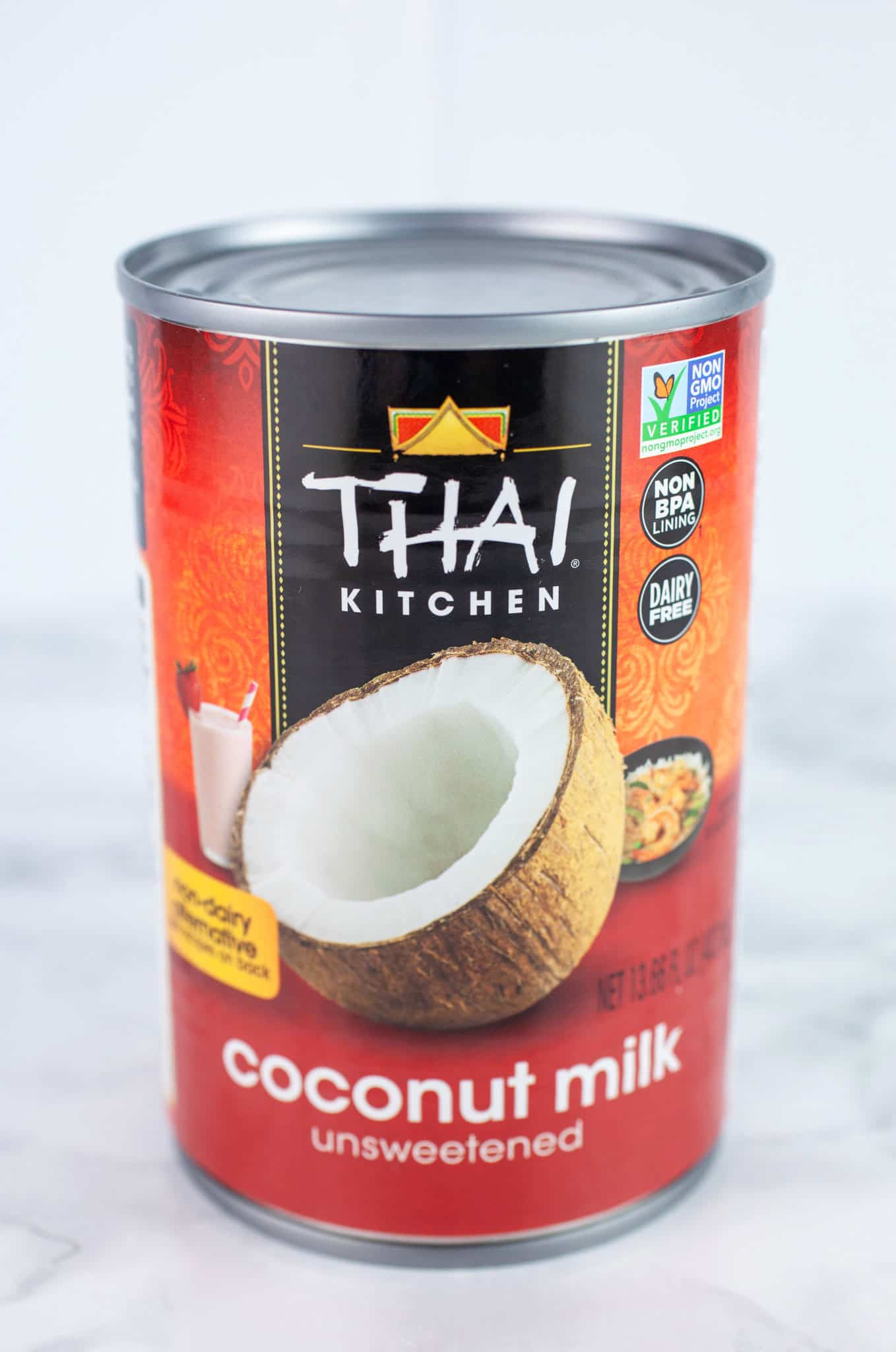 Unopened can of Thai Kitchen coconut milk on white surface.