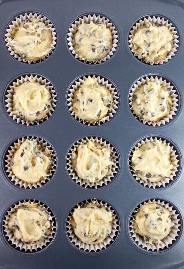 Unbaked chocolate chip cupcakes in muffin tin.