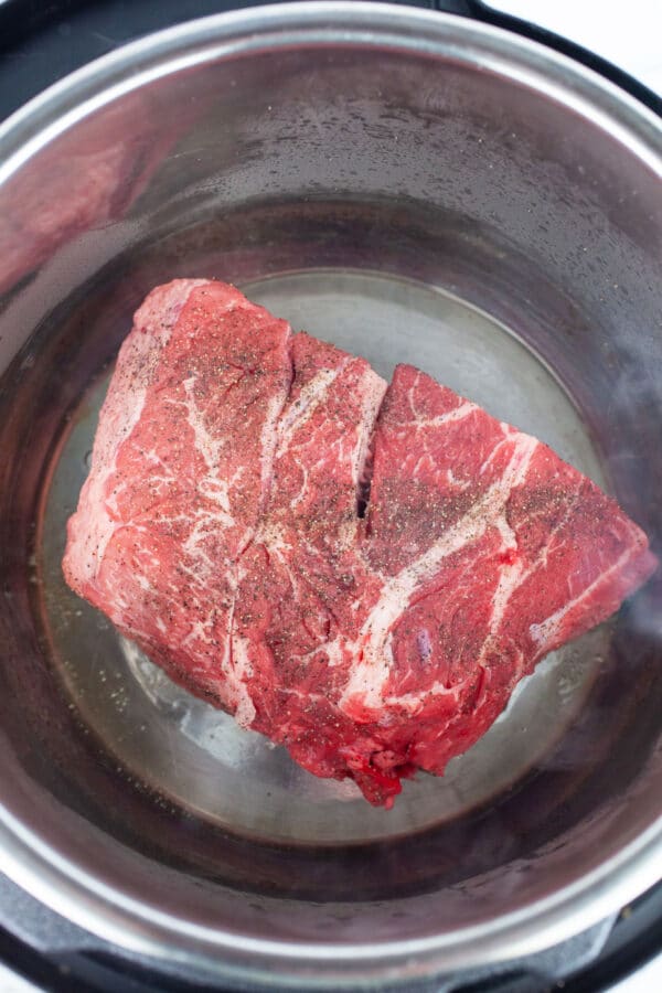 Uncooked beef chuck roast in Instant Pot.