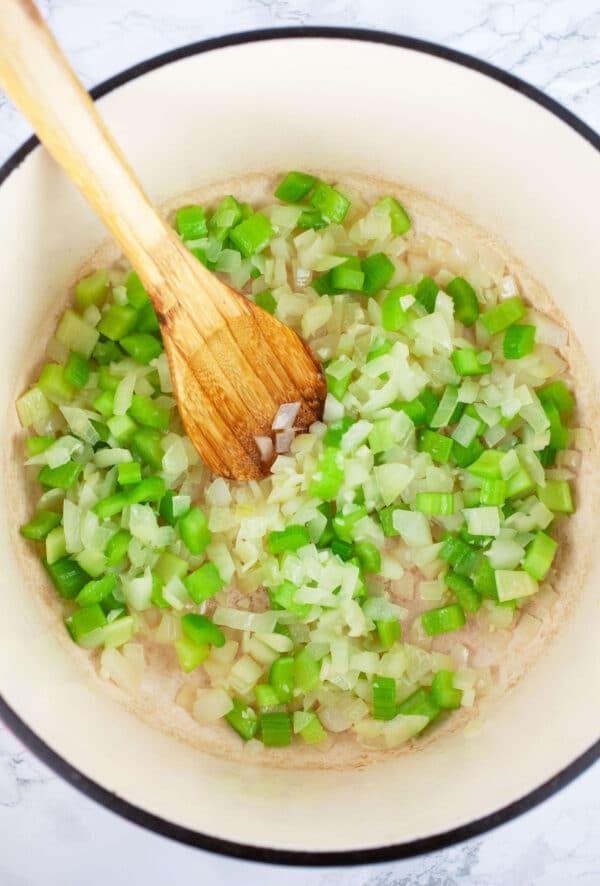 Minced garlic, onions, and celery sauteed in Dutch oven with wooden spoon.