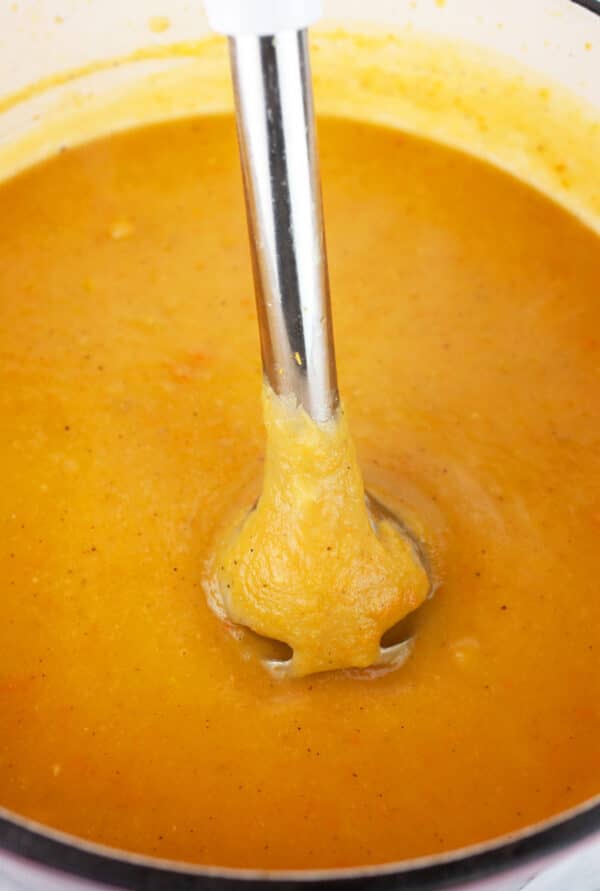 Root vegetable soup in Dutch oven pureed with immersion blender.