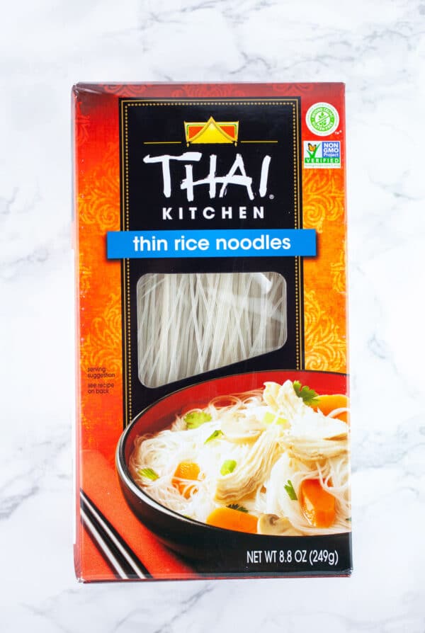 Unopened package of Asian rice noodles on white surface.