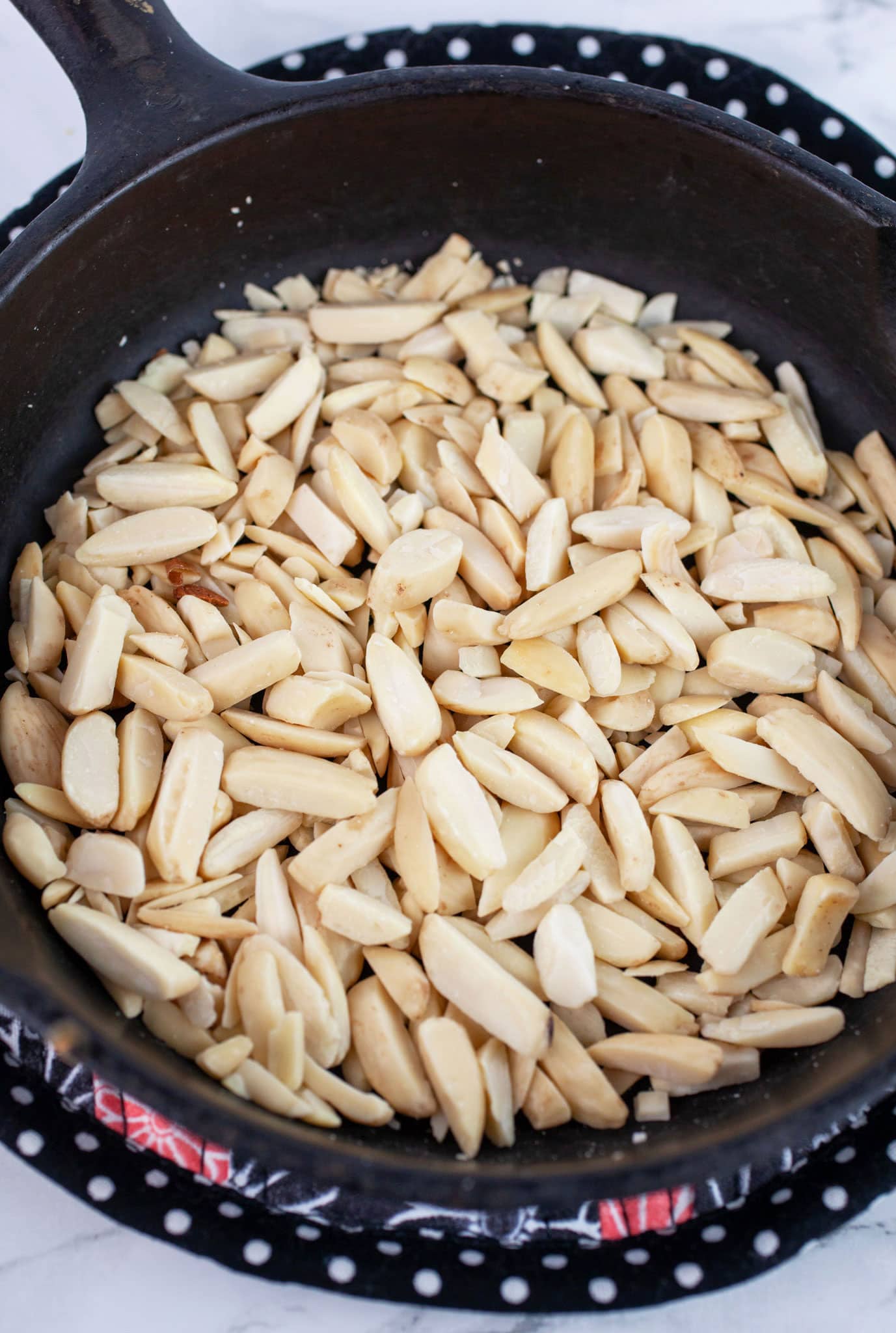 Toasted slivered almonds in small cast iron skillet.