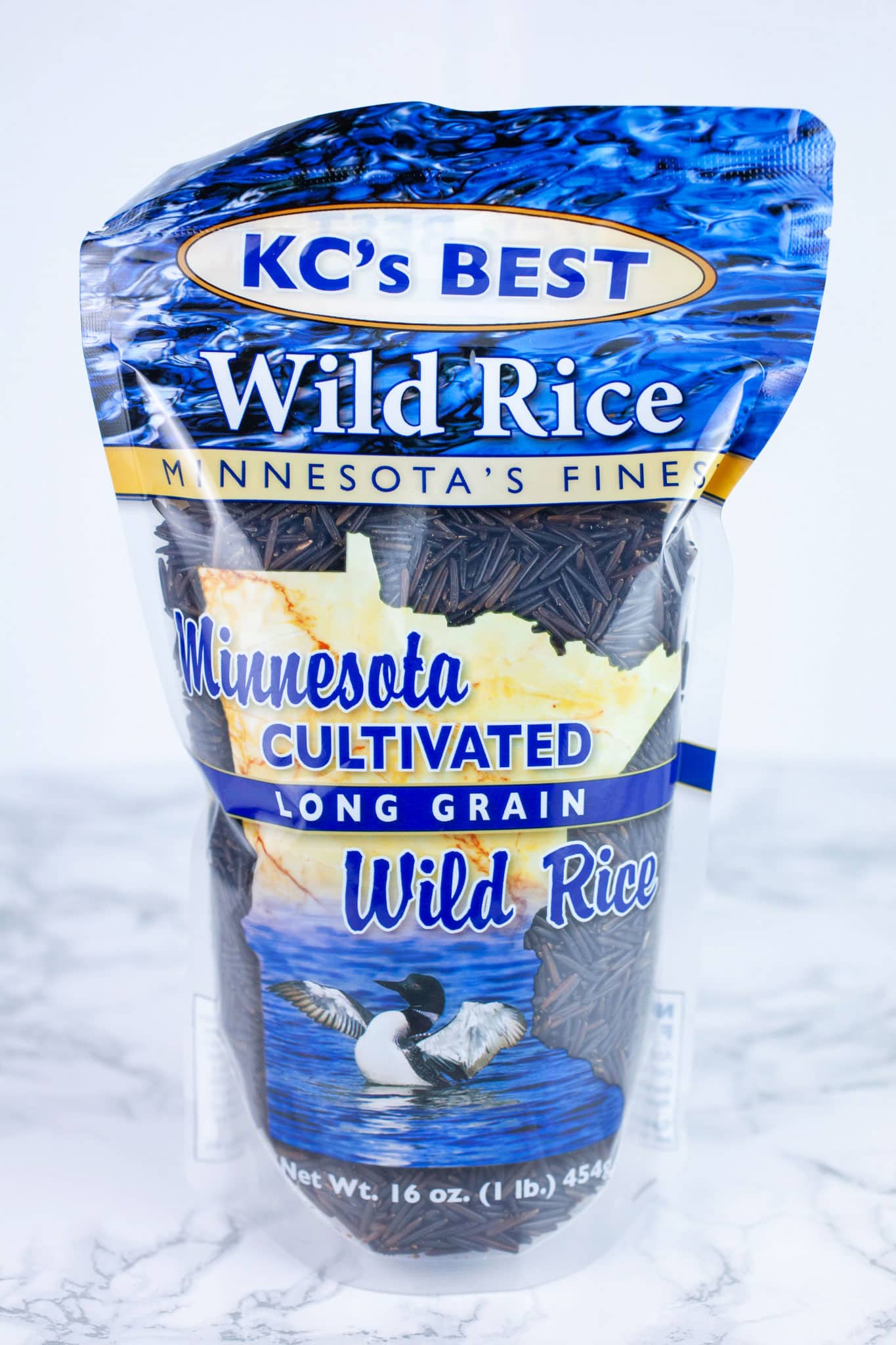 Unopened bag of wild rice on white surface.