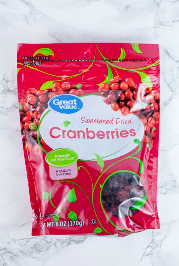 Unopened bag of dried cranberries on white surface.