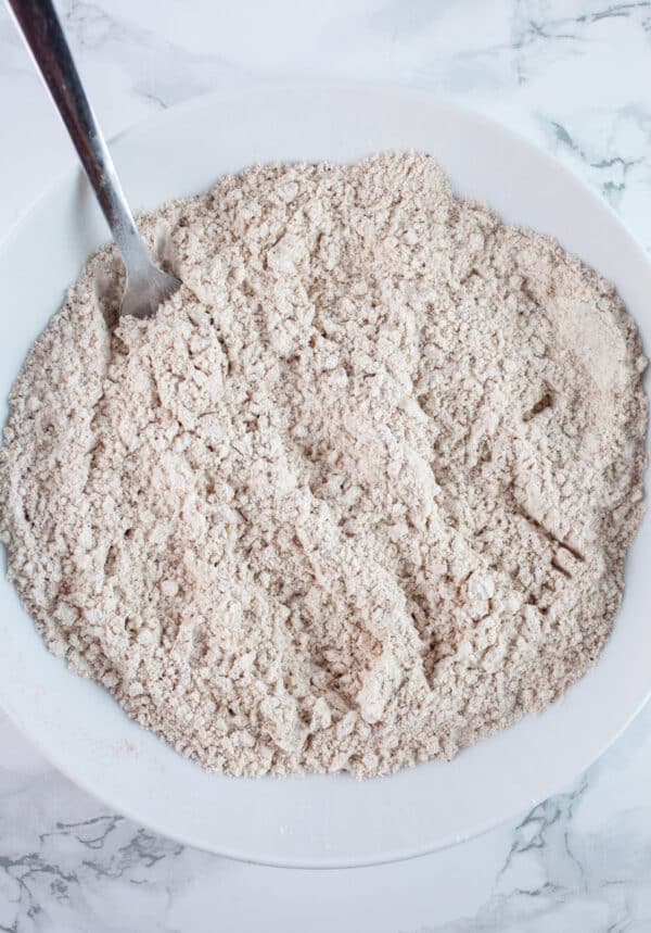 Seasoned gluten free flour blend in white bowl with fork.