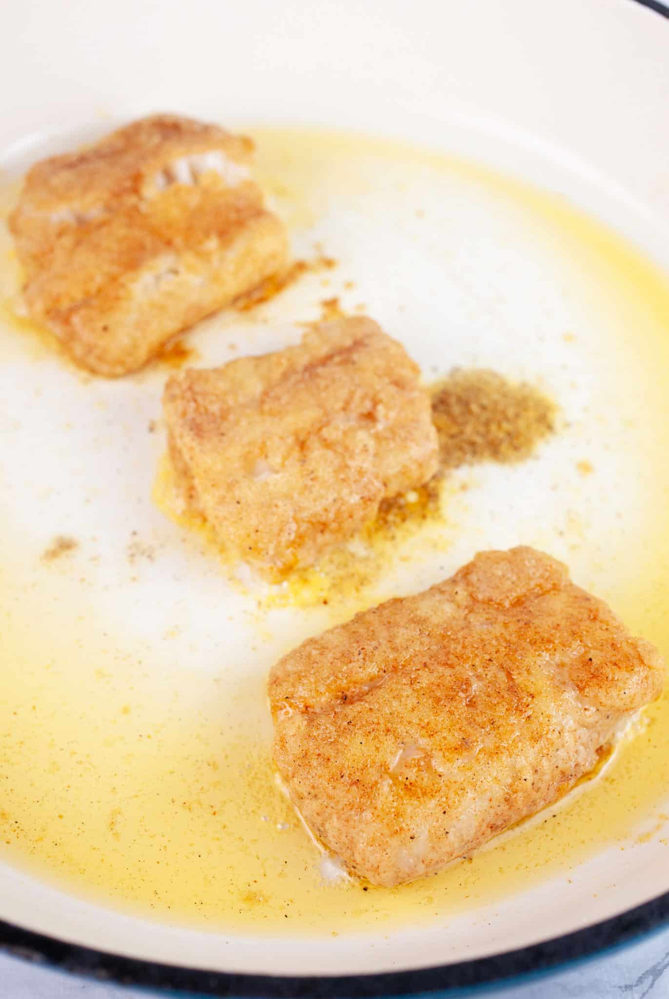 Fish filets sauteed with avocado oil in skillet.