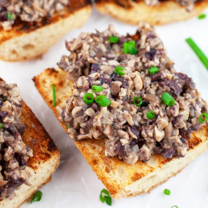 Mushroom tapenade on grilled baguette garnished with fresh chives.