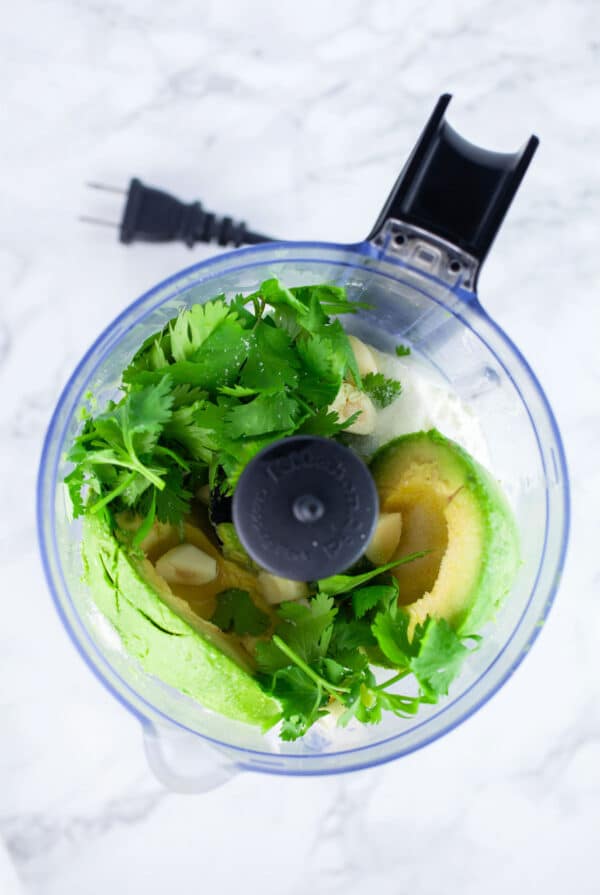 Avocado, sour cream, garlic, cilantro, lime juice, and kosher salt in food processor.