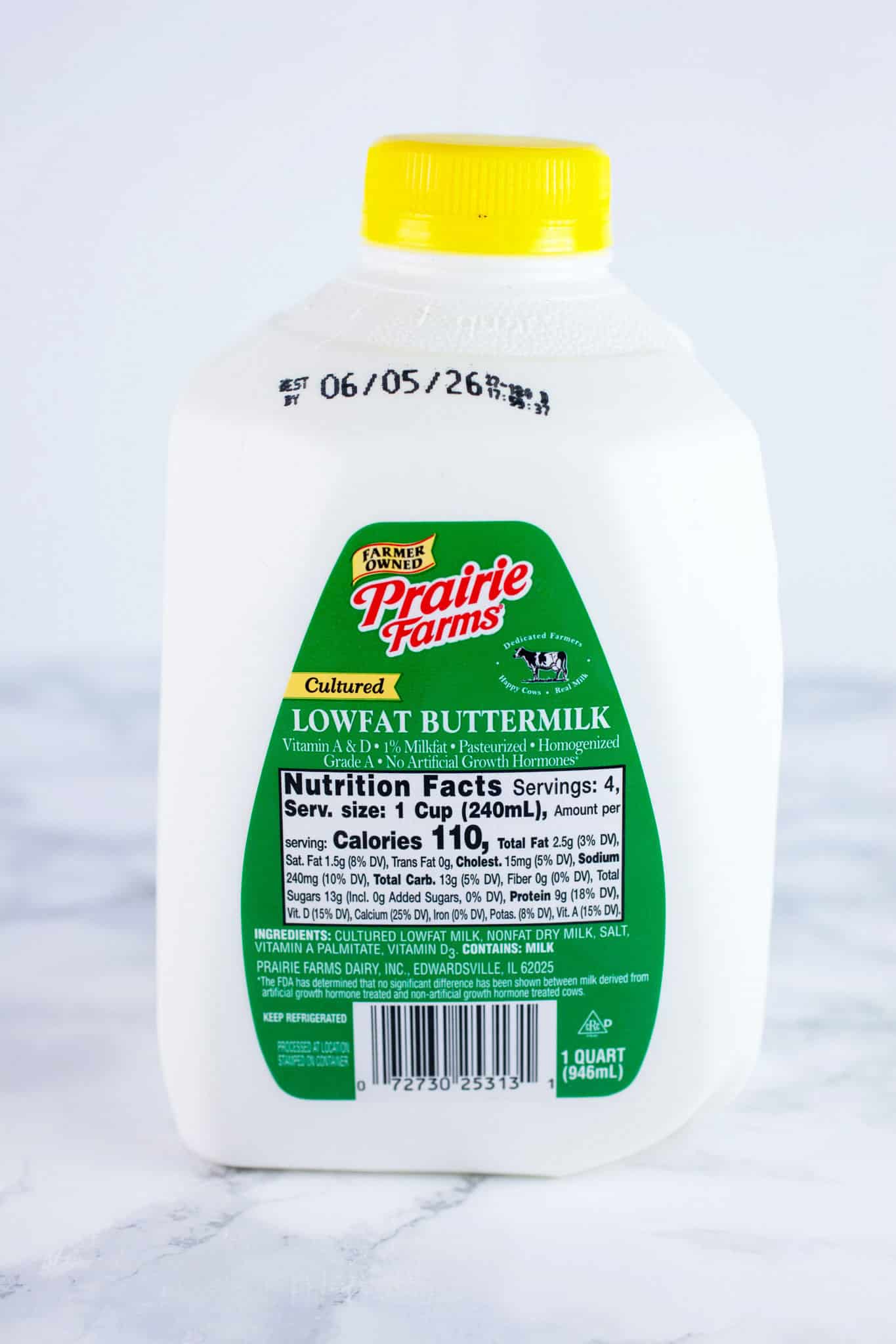 Unopened plastic jug of buttermilk on white surface.