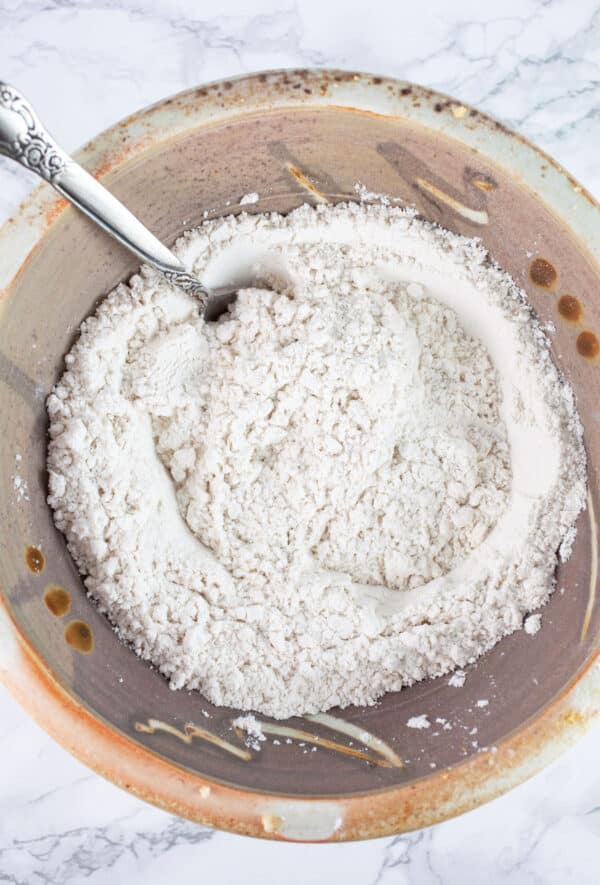 Dry ingredients in ceramic bowl with spoon.