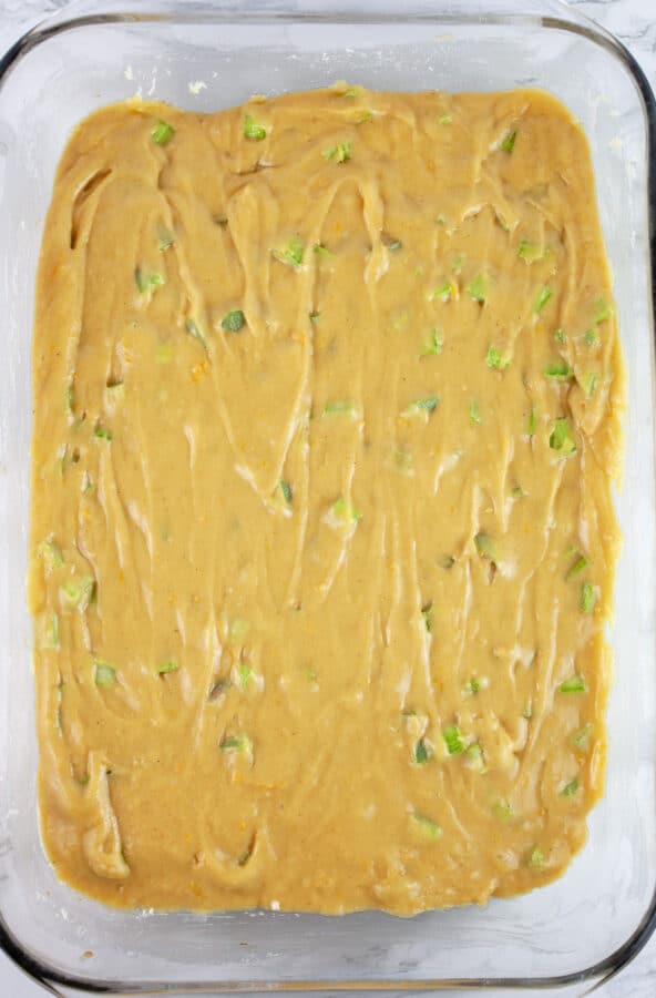 Unbaked rhubarb cake in glass baking dish.
