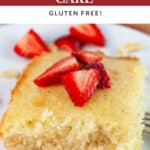 Lemon cardamom cake with fresh strawberries on white plate with fork.