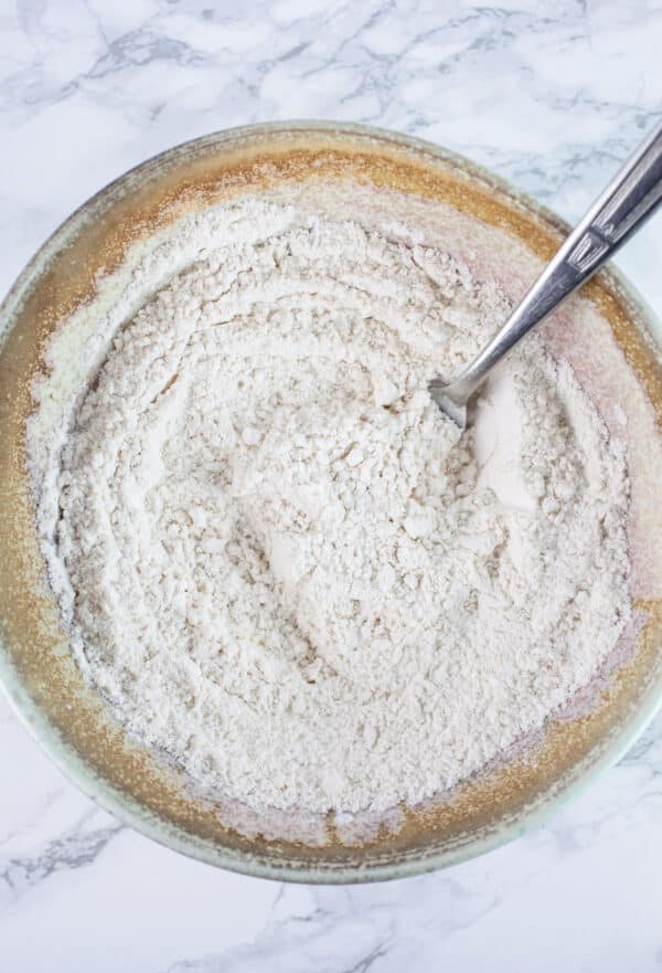 Dry ingredients combined in ceramic bowl with fork.