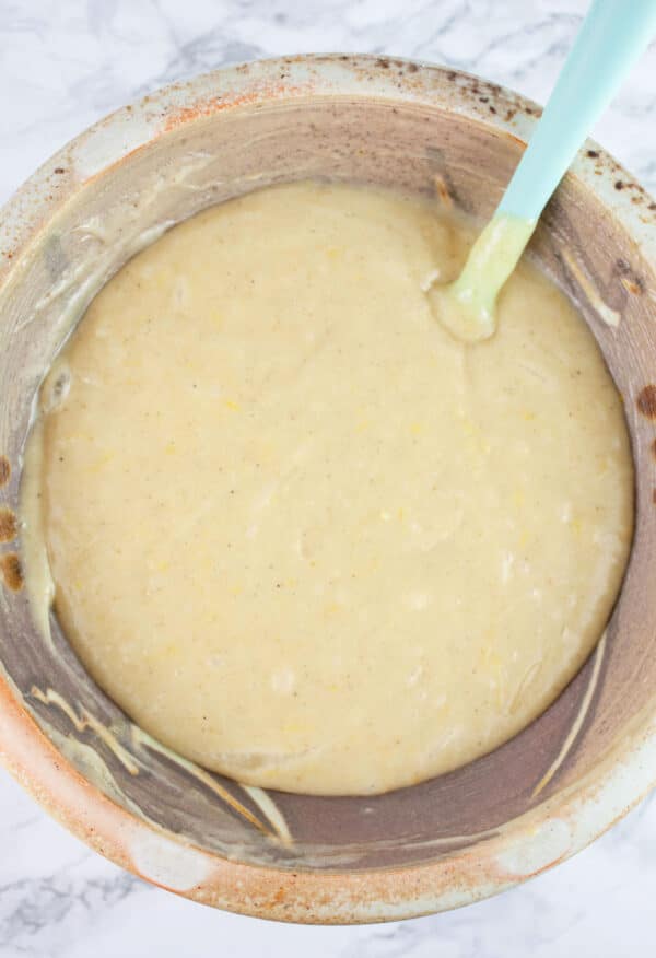 Cake batter combined in ceramic bowl with spatula.