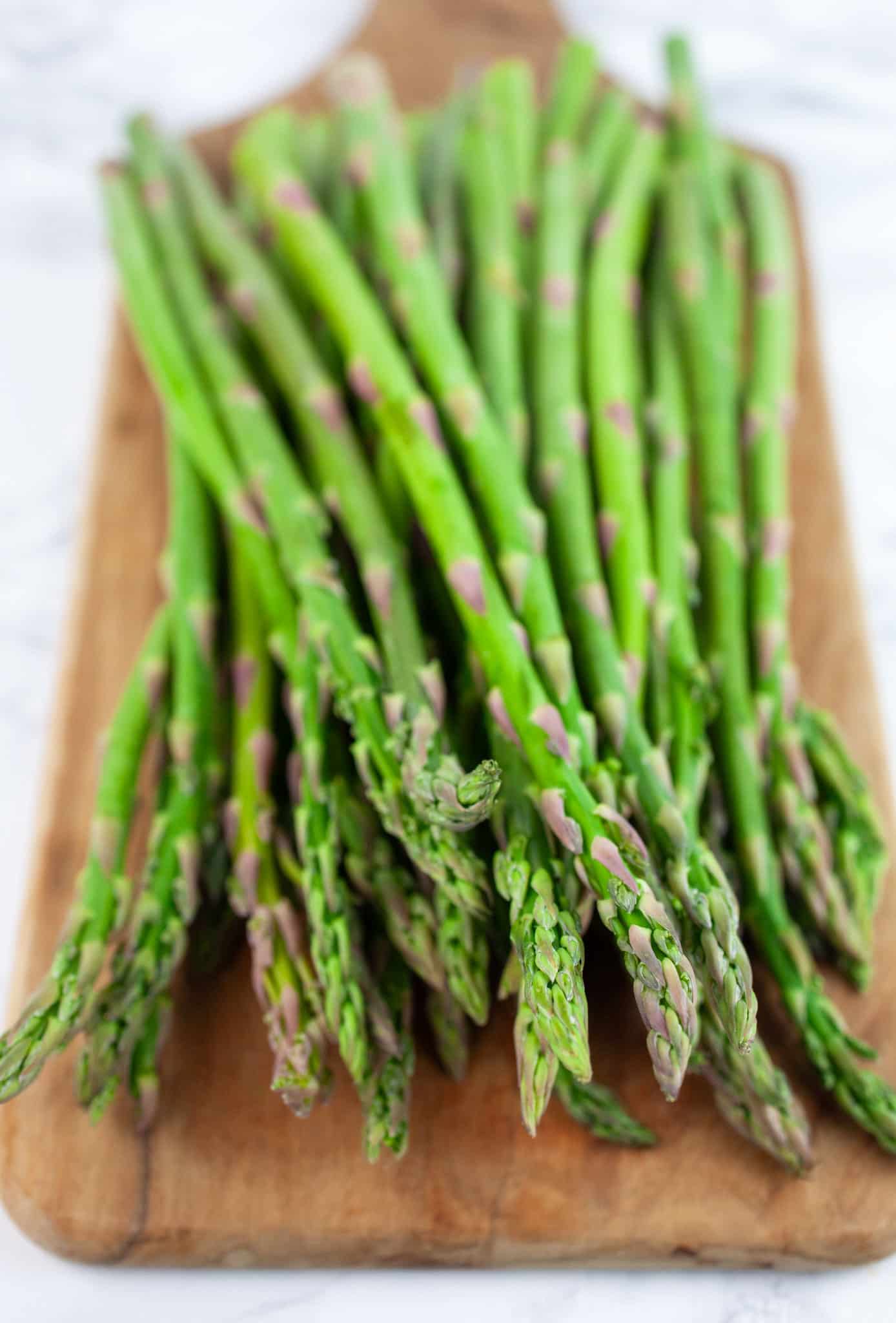 Asparagus spears on wooden serving board.