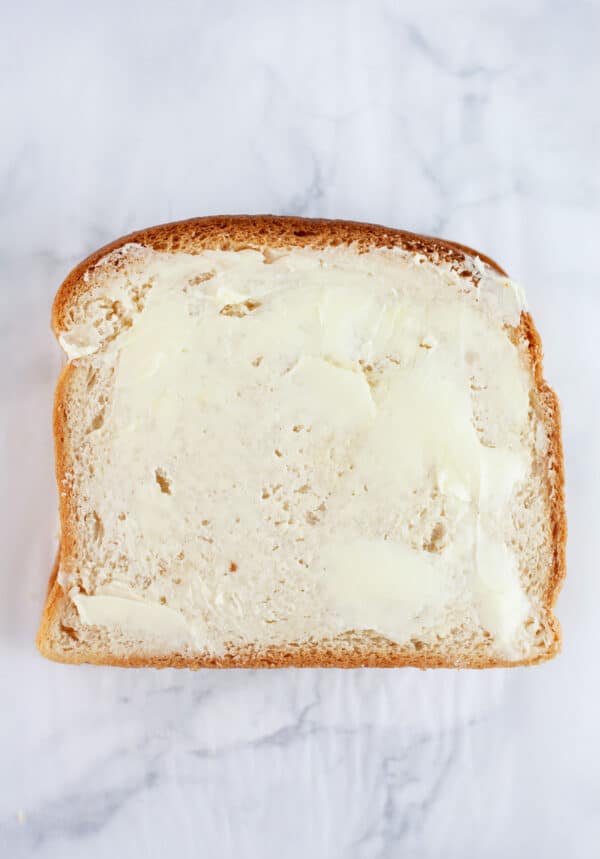 Sandwich with butter spread across surface of bread.