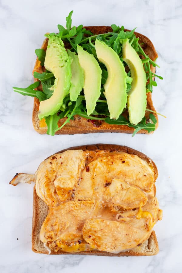Chicken chipotle panini with arugula and sliced avocado.