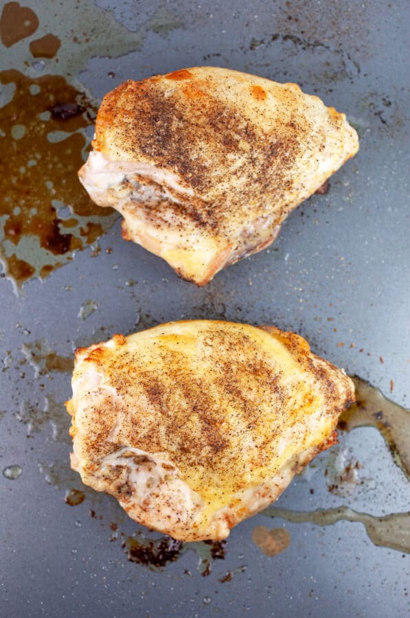 Roasted, split chicken breasts on baking sheet.