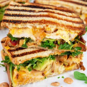 Chipotle chicken panini sandwich cut in half and stacked on itself.