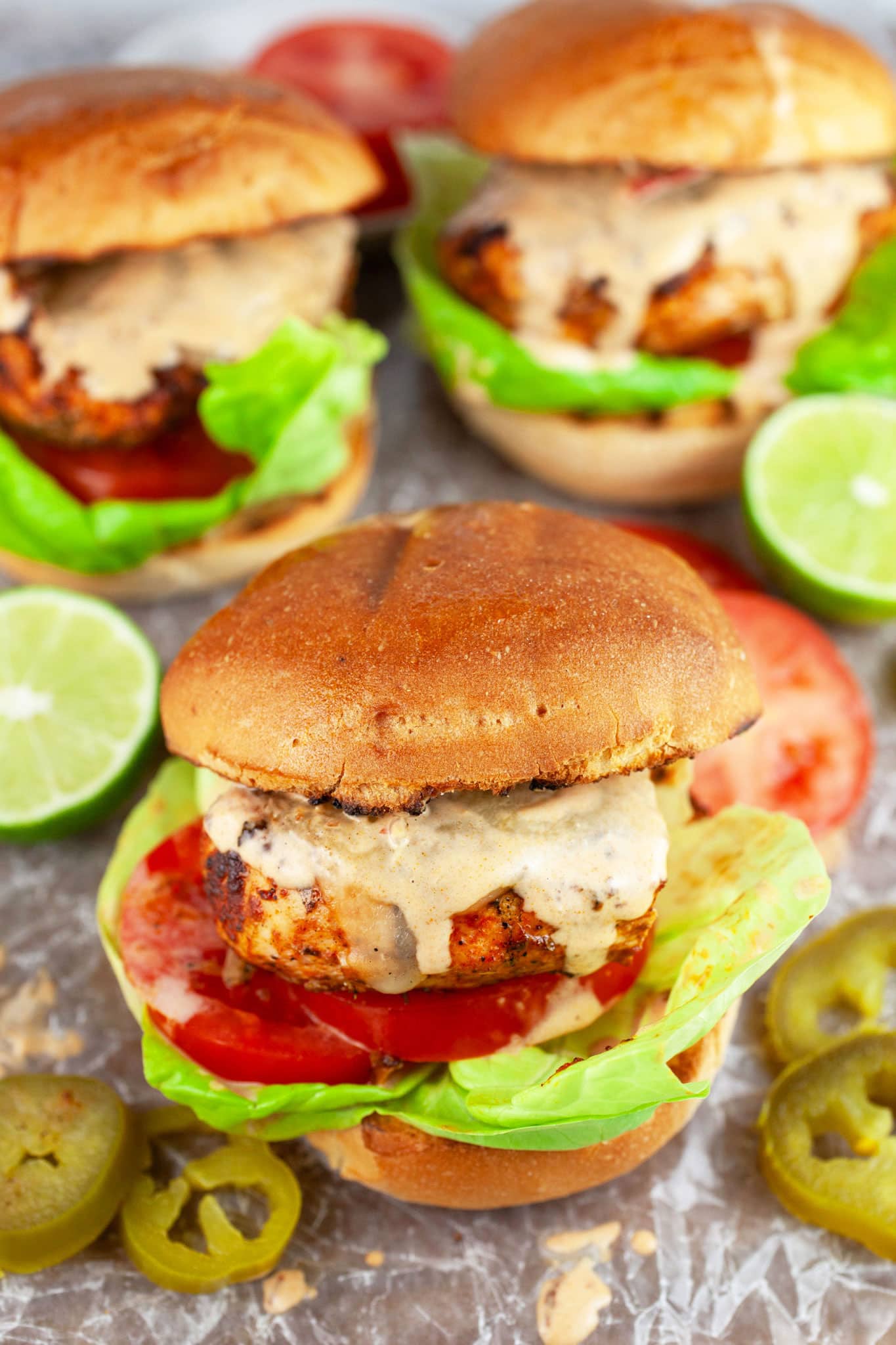 Southwest chicken sandwiches with lettuce, tomatoes, and chipotle sauce on buns.