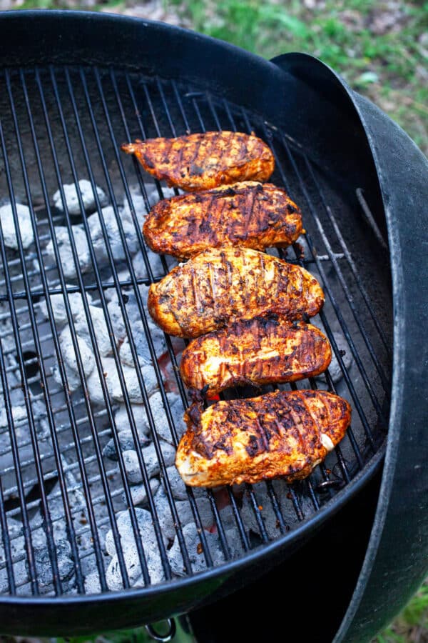 Cooked Southwest chicken breasts on charcoal grill.