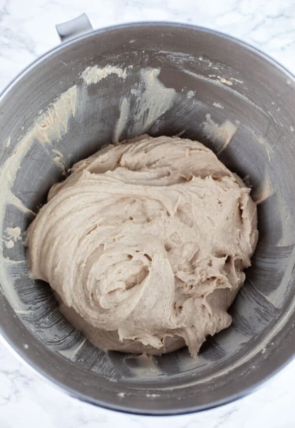 Wet pizza dough in large metal bowl.