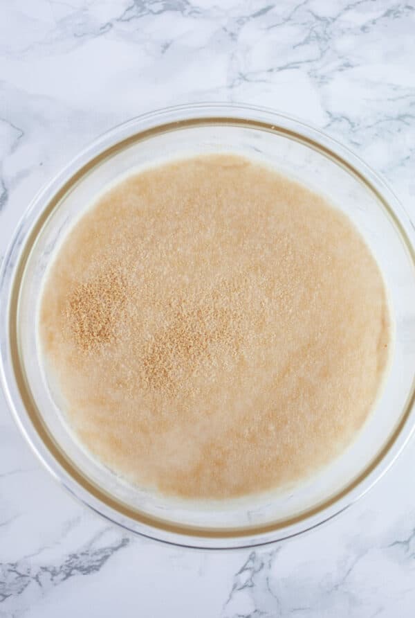 Yeast blooming in water in small glass bowl.