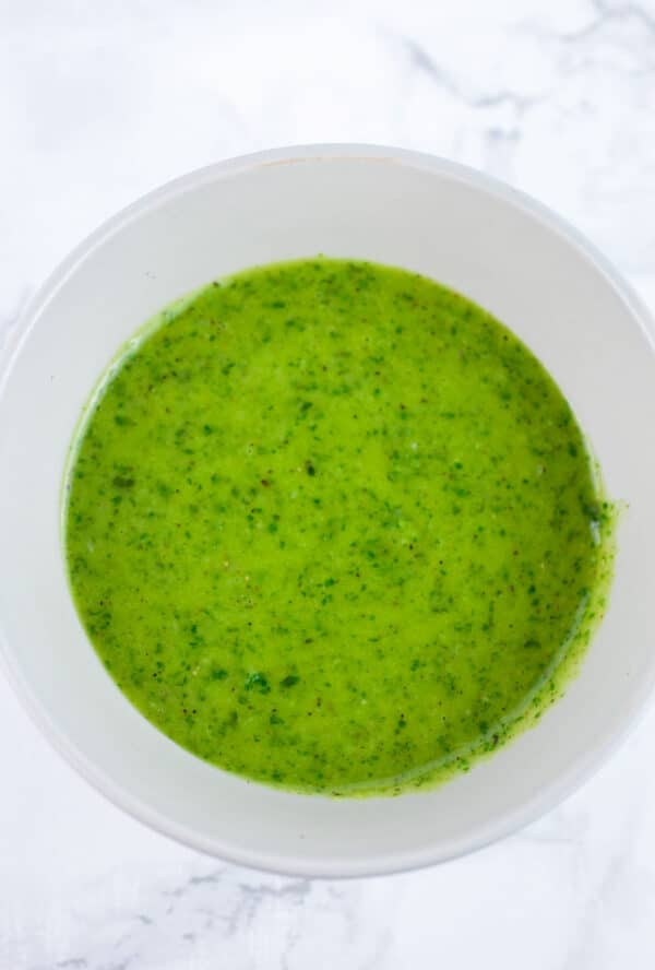 Basil vinaigrette dressing in small grey bowl.