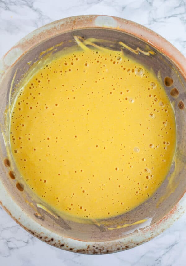 Pumpkin cheesecake mixture in ceramic bowl.