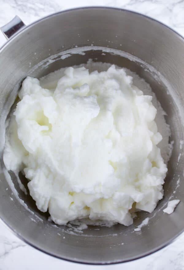 Whipped egg whites in stainless steel bowl.