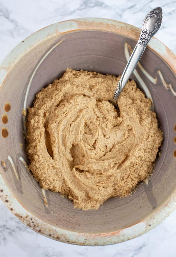 Wet ingredients in ceramic bowl with spoon.