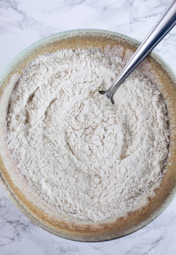 Dry ingredients in ceramic bowl with spoon.